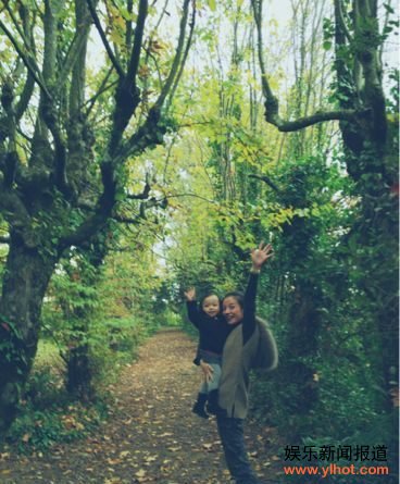 赵薇抱着女儿在小径中散步开心挥手面对镜头